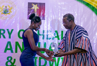 The UNFPA Country Rep a.i., Mr. Barnabas Yisa presenting an award to one of the midwives.. 