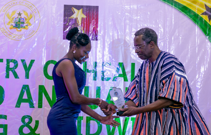 The UNFPA Country Rep a.i., Mr. Barnabas Yisa presenting an award to one of the midwives.. 